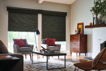 Wooden, woven shades in a Kansas City home's living space, complimenting the natural wood furniture. Available at The Blind Broker.