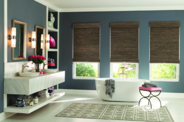 Wooden woven shades within a home's bath area, contrasting with the neutral room colors and textures. Available at The Blind Broker.