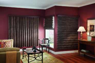 A dark, romantic living space accented with natural wooden woven shades to filter natural light. Available at The Blind Broker.