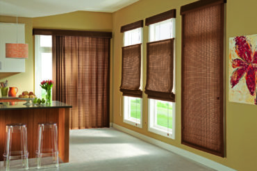 Wooden woven shades from The Blind Broker of Kansas City within a home's kitchen, extending the natural wood shade used in the furniture.