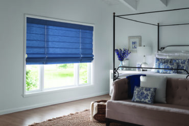 Roman shades in blue fabric to match the decor of the bedroom they're featured in. Available at The Blind Broker of Kansas City.