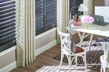 Artisan drapes accenting dark-finish wooden shades in a home office. Available at The Blind Broker of Kansas City.
