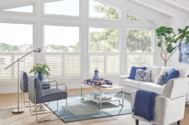 Graber wood cafe panel shutters in a home's living room, accenting the custom window shapes. Available at The Blind Broker of Kansas City.