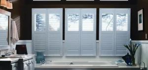 White plantation shutters against a dark burgundy wall in a Kansas City home.